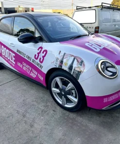 Custom car signage Melbourne with full vehicle wrap showcasing business branding on city roads